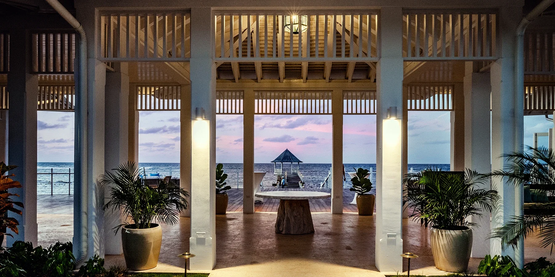 The Ooshan pavilion at dusk, its columns framing the pier and gazebo over the sea